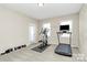 Bright exercise room with large windows, carpet flooring, and various fitness equipment at 4146 La Crema Dr, Charlotte, NC 28214