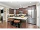 A large kitchen island with bar stools, stainless steel appliances, and dark cabinets at 4146 La Crema Dr, Charlotte, NC 28214