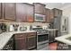 Gourmet kitchen with stainless steel appliances, granite countertops, and dark wood cabinetry at 4146 La Crema Dr, Charlotte, NC 28214