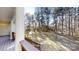 Back porch showing columns, railing and wooded backyard with sunlight streaking through trees at 8046 Lucky Creek Ln, Denver, NC 28037