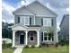 Two-story home with gray siding, black shutters, stone accents, and a covered front porch at 9601 Pointer Rd # 77, Huntersville, NC 28078