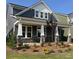 Stylish home with a covered porch featuring stone supports and manicured landscaping at 9605 Pointer Rd # 78, Huntersville, NC 28078