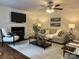 Cozy living room with fireplace, ceiling fan, and plush seating, perfect for relaxation at 9709 Calpher Ct, Matthews, NC 28105