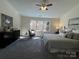 Cozy main bedroom featuring a ceiling fan, window, sitting chair, and comfortable bed at 9709 Calpher Ct, Matthews, NC 28105