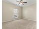 Carpeted bedroom with a ceiling fan and window for natural light at 10302 Sawtimber Ct, Huntersville, NC 28078