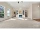 Open-concept living room with a fireplace, built-in shelving, and large windows allowing for natural light at 10302 Sawtimber Ct, Huntersville, NC 28078