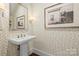 Elegant powder room with pedestal sink and leaf patterned wallpaper at 1117 Churchill Commons Dr, Charlotte, NC 28211