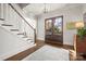 Inviting foyer with a staircase, dark wood floors, and a striking dark wood front door at 1117 Churchill Commons Dr, Charlotte, NC 28211