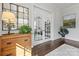 Bright foyer featuring dark hardwood floors, white trim, glass french doors, and decorative furnishings at 1117 Churchill Commons Dr, Charlotte, NC 28211