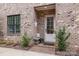 White door side entrance with brick accents and small shrubs at 1117 Churchill Commons Dr, Charlotte, NC 28211