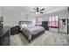 Main bedroom with gray bedding and ceiling fan at 8411 Washoe Pine Ln, Charlotte, NC 28215