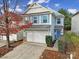 Two-story house with a blue door, attached garage, and landscaping at 8411 Washoe Pine Ln, Charlotte, NC 28215