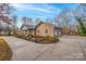 Brick home featuring a well-manicured front yard, mature trees, and an extended driveway at 1115 Stony Point Rd, Kings Mountain, NC 28086