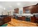 Well-equipped kitchen featuring stainless steel appliances, dark wood cabinets, granite countertops, and stylish hardwood floors at 1115 Stony Point Rd, Kings Mountain, NC 28086