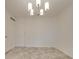 An empty living room with neutral walls, tiled floors, and a modern chandelier at 1300 Queens Rd # 303, Charlotte, NC 28207