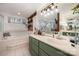 Stylish bathroom with a soaking tub, green cabinets, and wood accents, offering a luxurious and spa-like experience at 15215 Timberview Ln, Huntersville, NC 28078