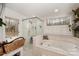 Bright bathroom featuring a glass shower and soaking tub with jacuzzi jets with two windows providing natural light at 15215 Timberview Ln, Huntersville, NC 28078