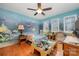 Bright bedroom with an ocean themed mural, a ceiling fan, hardwood floors and three windows at 15215 Timberview Ln, Huntersville, NC 28078
