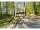 A long, gated driveway leads to a brown house nestled among lush trees and landscaping at 15215 Timberview Ln, Huntersville, NC 28078