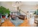 Spacious living room boasts a vaulted ceiling, wood floors, and a staircase that leads to a second-floor loft at 15215 Timberview Ln, Huntersville, NC 28078