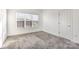 Neutral bedroom featuring plush carpet, a large window, and a white door at 174 Bellingshire Dr, Mt Ulla, NC 28125