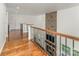 Hallway with hardwood floors, iron railing, stone accent wall with fireplace below, and recessed lighting at 174 Bellingshire Dr, Mt Ulla, NC 28125