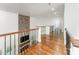 Hallway with hardwood floors, iron railing, stone accent wall with fireplace below, and recessed lighting at 174 Bellingshire Dr, Mt Ulla, NC 28125