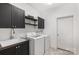 Laundry room featuring a laundry sink, cabinets, and modern appliances at 174 Bellingshire Dr, Mt Ulla, NC 28125