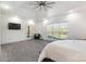 Large main bedroom with tray ceilings, plush carpet, ceiling fan, tv, and large windows at 174 Bellingshire Dr, Mt Ulla, NC 28125