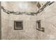 Close up of new shower with stone-look tile, decorative tile accents and built-in shampoo niches at 174 Bellingshire Dr, Mt Ulla, NC 28125