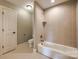 A white bathtub and tiled shower in a bathroom with beige walls and a white door at 546 Little Cove Ln, Lake Wylie, SC 29710