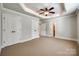 Large bedroom with tray ceiling, ceiling fan, and multiple closets and door frames at 546 Little Cove Ln, Lake Wylie, SC 29710