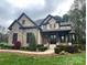 Gorgeous stone and stucco home featuring lush landscaping and a covered front entry at 546 Little Cove Ln, Lake Wylie, SC 29710