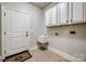 Laundry room featuring utility sink, overhead cabinets, tile floors, and entry door at 546 Little Cove Ln, Lake Wylie, SC 29710