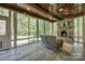 Sun room with stone fireplace, wood ceilings, ceiling fan, and multiple windows at 546 Little Cove Ln, Lake Wylie, SC 29710