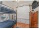 Bedroom with a bunk bed, built-in storage, and wood floors at 108 Elm St, New London, NC 28127