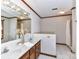 Bathroom featuring double sinks, wood cabinets, and a shower with tile surround at 1805 Tufnell Ct, Charlotte, NC 28262