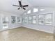 Bright sunroom surrounded by windows, tile flooring, and a ceiling fan for comfort at 1805 Tufnell Ct, Charlotte, NC 28262