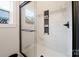 Modern shower with marble-like tile and built-in shelves with glass door and matte black hardware at 625 Charles St, Rockwell, NC 28138