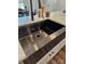 Close-up of a large stainless steel kitchen sink with a modern matte black faucet and white countertops at 625 Charles St, Rockwell, NC 28138