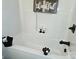 Close up of tub with white surround, black fixtures and modern decor at 625 Charles St, Rockwell, NC 28138