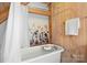 Relaxing bathroom featuring a clawfoot tub, wooden walls, and natural light at 917 Patrick Johnston Ln, Davidson, NC 28036