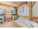 Luxurious bathroom featuring a soaking tub, wooden beams, and tiled flooring at 917 Patrick Johnston Ln, Davidson, NC 28036