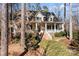 Inviting two-story home with a charming front porch, mature trees, and a well-manicured lawn at 917 Patrick Johnston Ln, Davidson, NC 28036