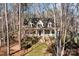 Charming two-story home with inviting front porch and brick stairs, surrounded by mature trees at 917 Patrick Johnston Ln, Davidson, NC 28036