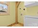 Well-lit laundry room with cream walls, tiled floor, window, and white cabinetry offers convenience at 917 Patrick Johnston Ln, Davidson, NC 28036