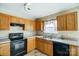 Kitchen with black appliances and wood cabinets at 9315 Ames Hollow Rd, Charlotte, NC 28216