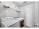 Laundry room with washer, dryer, and ample shelving at 9315 Ames Hollow Rd, Charlotte, NC 28216