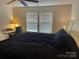 Bright bedroom with a large bed, desk, and two windows at 9514 Currier Rd, Charlotte, NC 28215