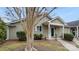 Quaint home featuring a well-kept yard and a welcoming covered entrance with a bright green front door at 2712 New Hamlin Way, Charlotte, NC 28210